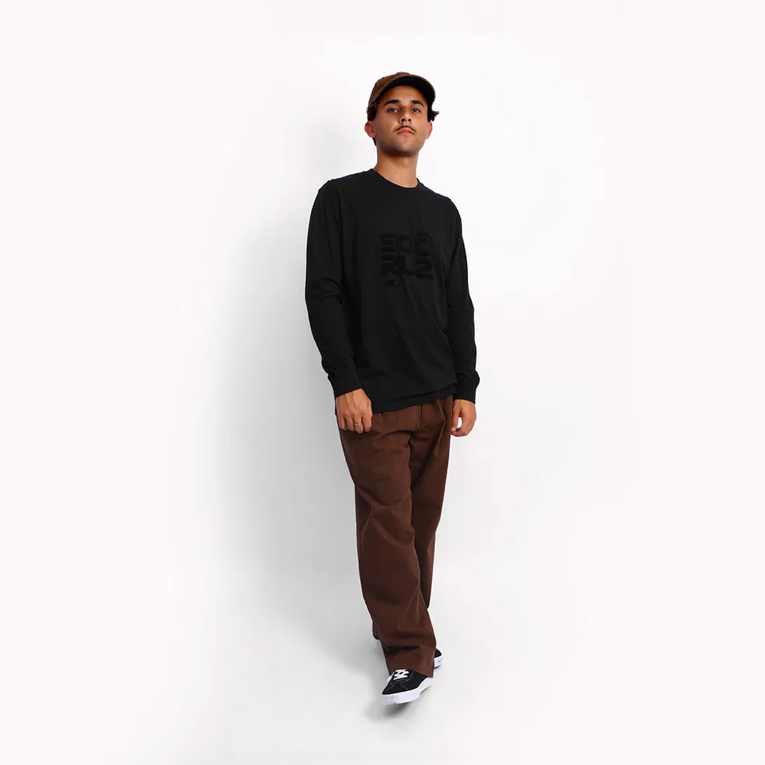 Man in a Soöruz long-sleeve T-shirt and brown trousers